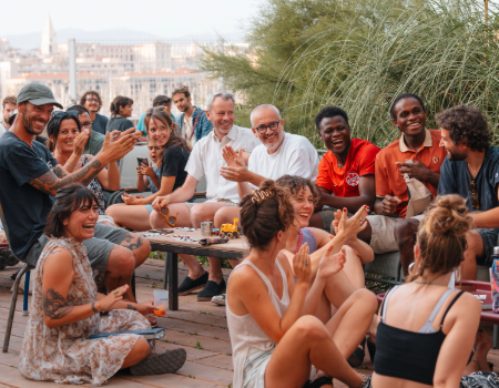 People gathered together, engaging in conversation and sharing a convivial moment in a warm and welcoming atmosphere.